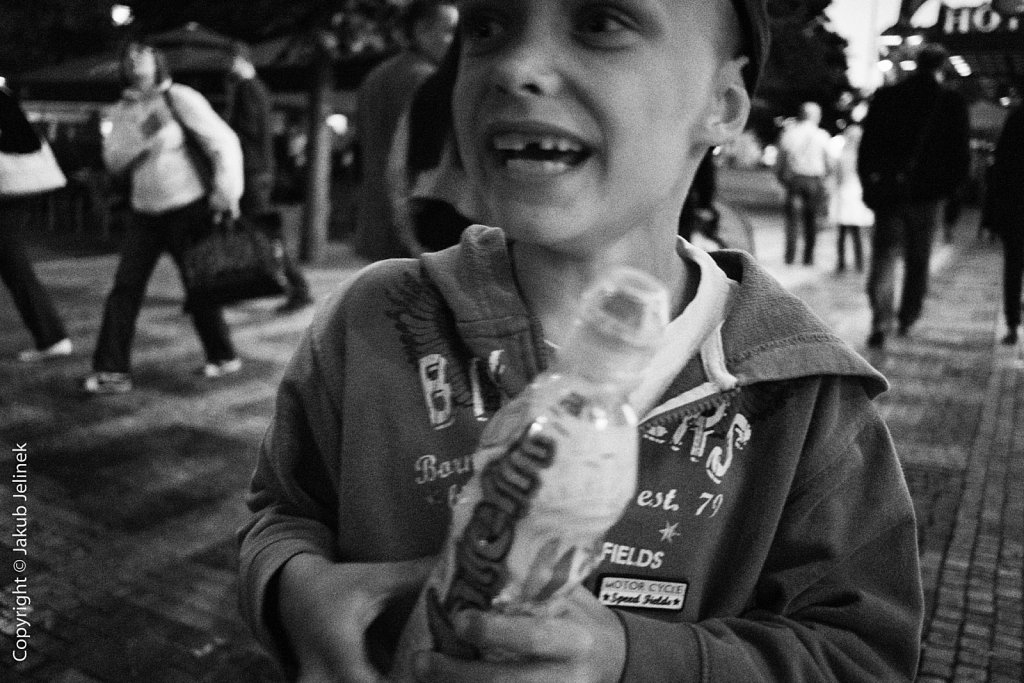A boy holding an ice cream in a busy street
