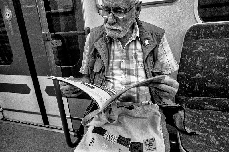 A man reading a newspaper on public transport
