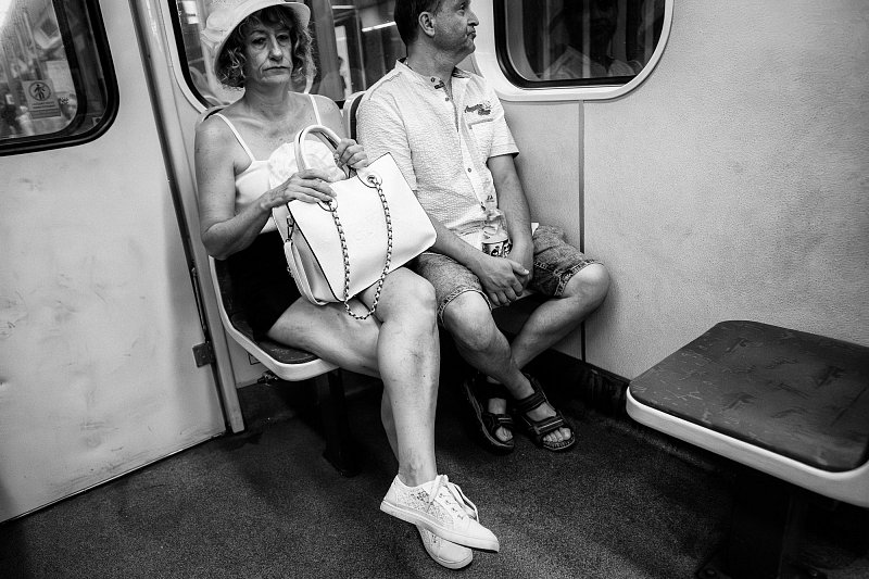 Two passengers sitting together in a metro carriage